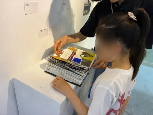Visitors turning pages to experience rhythm, breath, and time through physicality